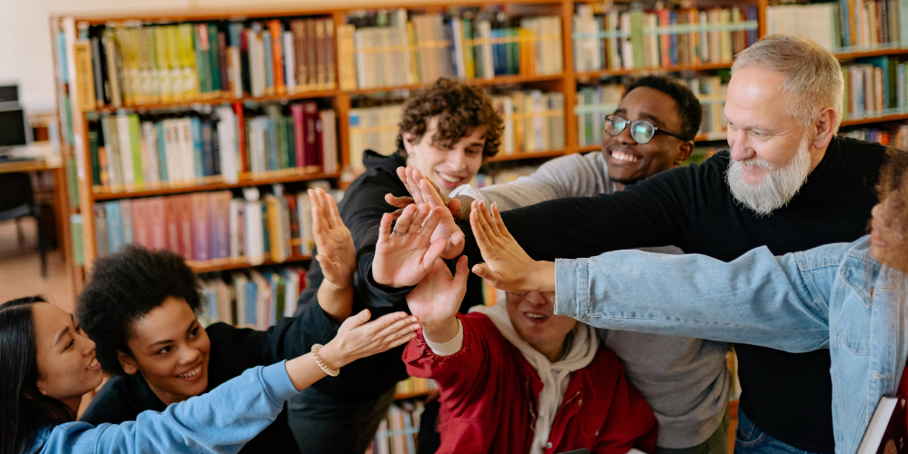 students and teacher creating a sense of belonging in school together by celebrating with high fives